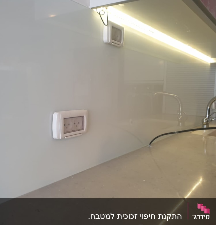 קיר זכוכית במטבח עם ברזים וכיור